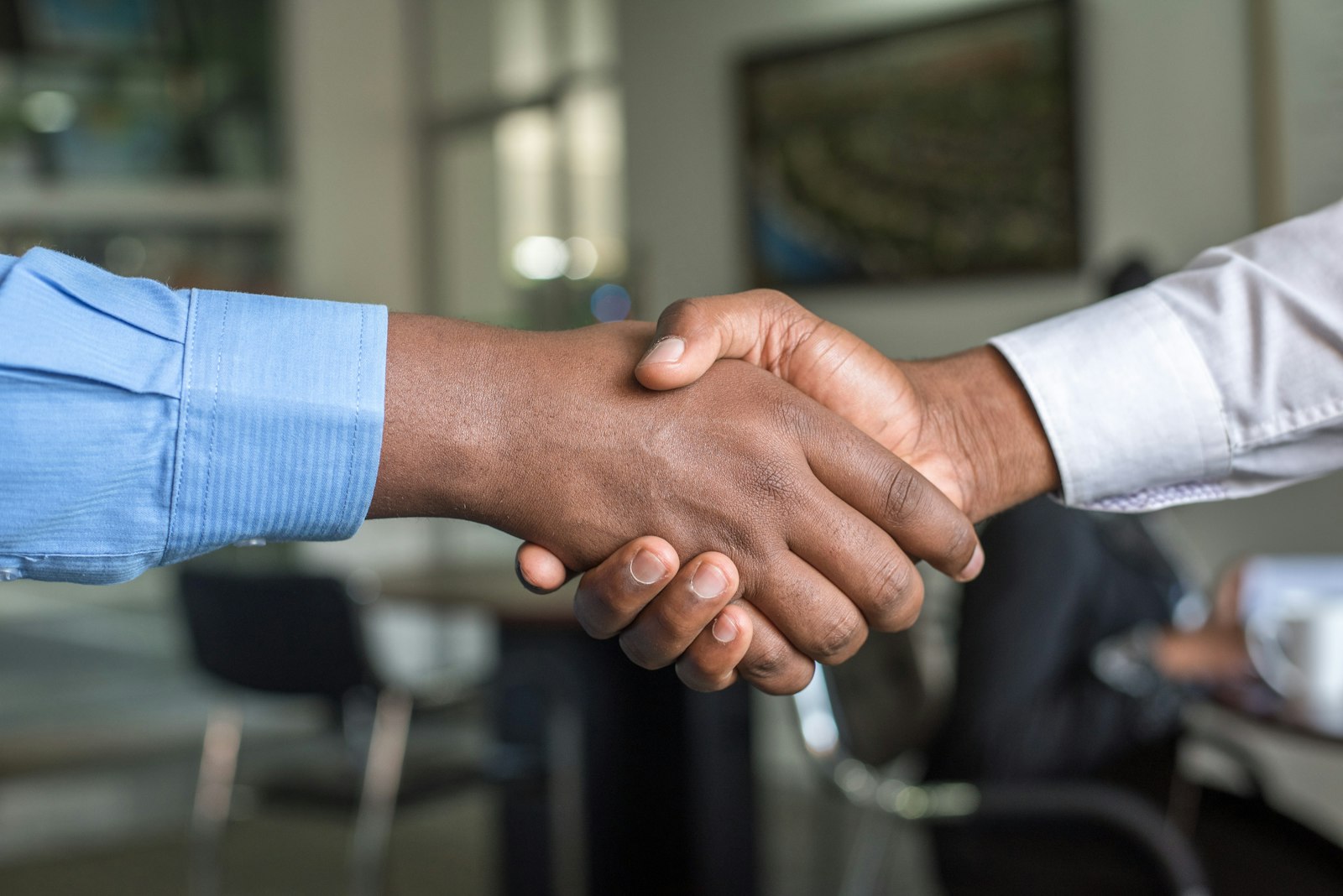 Professional handshake representing FAQ answers on immigration